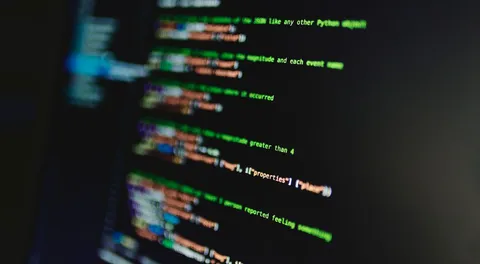 Linhas de código coloridas em tela de computador, em foco suave